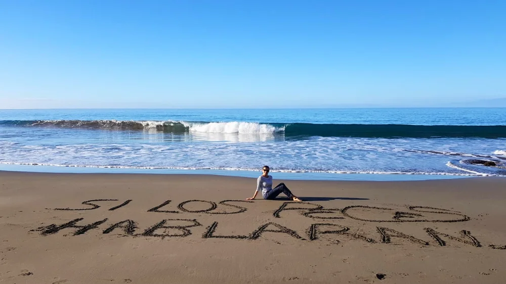 El título Si los peces hablaran… escrito sobre la arena de la playa